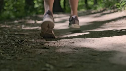 Morning run in the park, close-up of a man's sneakers as he runs away from the camera, embracing an