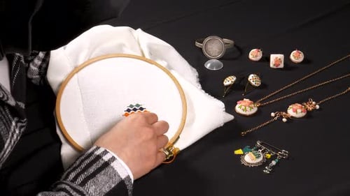 Hands Embroidering Floral Jewelry
