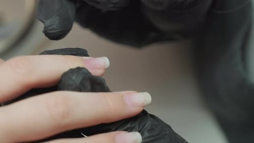 Close Up of Nail Technician Applying Hardener on Fingernail