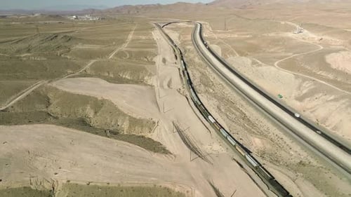 Long Cargo Train in Nevada Beside Vehicles on Asphalt Road