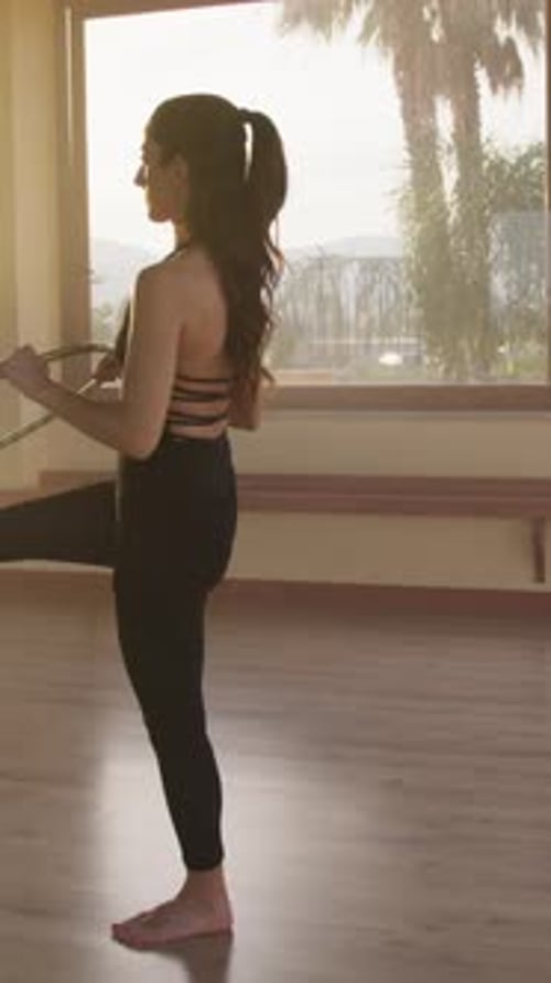 Young Woman Exercises with Hula Hoop in Studio