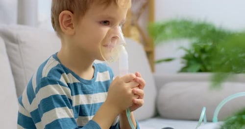 Young Boy Using Nebulizer Mask at Home