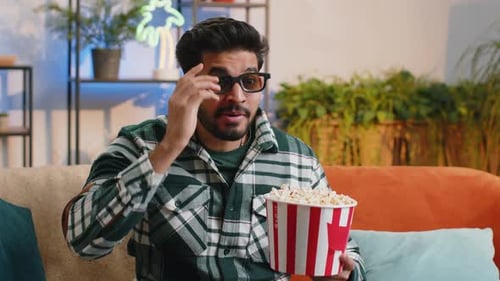 Man Eating Popcorn at Home on Couch