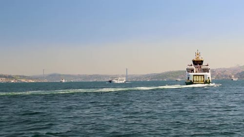 Medium Shot of Ferry Moving Through Bosphorus with City Backdrop