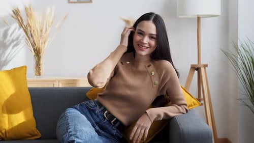 Lächelnde Frau sitzt auf dem Sofa