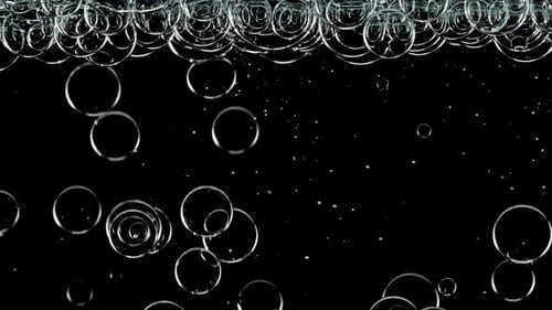 Blue Clear Bubbles Form and Float to Another Ones on Transparent Surface on Black Background The