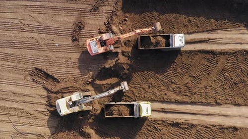 Excavators Fill Dump Trucks With Dirt
