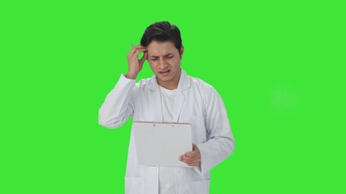Confused Indian scientist writing observations on papers Green screen
