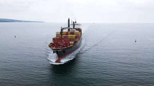 Aerial View of a Large Cargo Ship Carrying Colorful Containers Approaching the Port Maritime