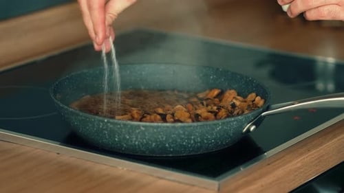 Adding Seasoning to food in Frying Pan