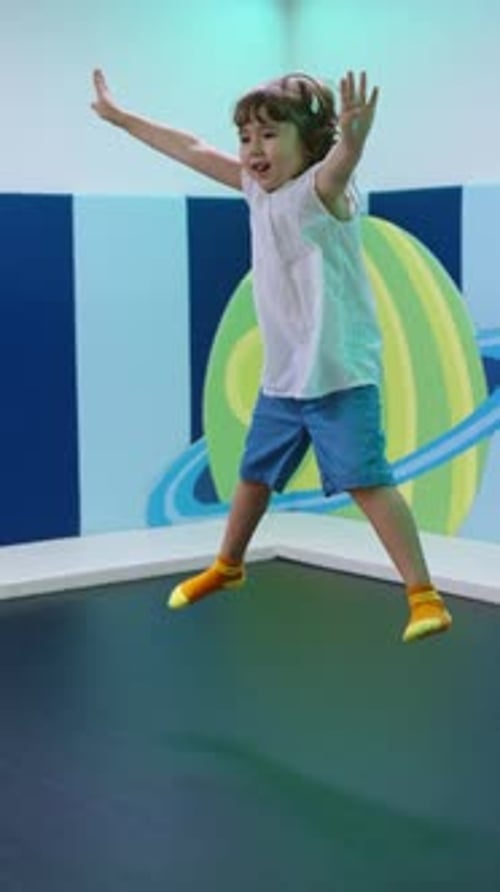 Child Jumps on Trampoline in Play Area
