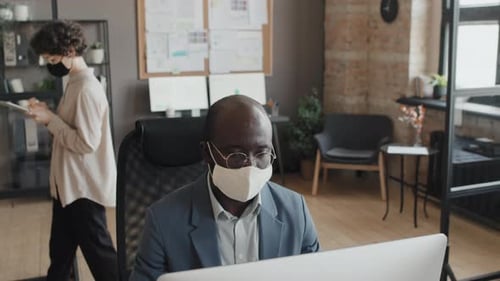 Directeurs portant des masques travaillant au bureau