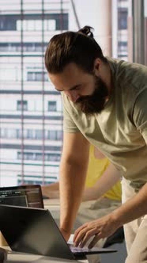 Vertical Video Man Monitoring Company Systems Using Notebook While Standing in Office