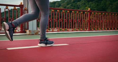 Legs Jogging on Red Bridge Running Path