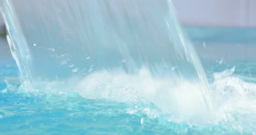 In the spa pool, water flows into the Hydromassage Bath, a small waterfall for massage, on a blue