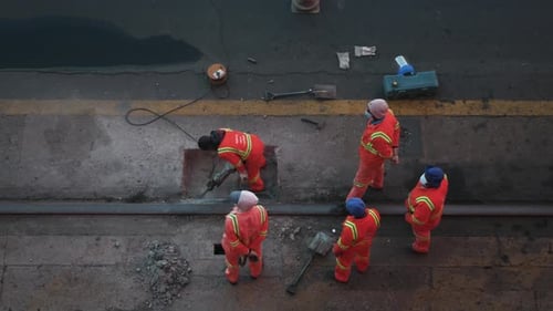Jackhammer machine destroying asphalt road. Road workers.