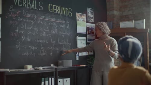 Female Teacher Explains Lesson to Student in Classroom