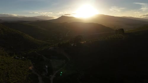 The golden glow of a sunset behind mountain range