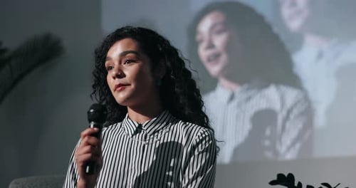 Young Adult Speaking at Conference Holding Microphone