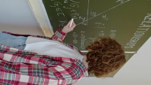 Student Writes Math Equations on Chalkboard