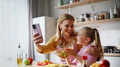 Smiling Woman and Child Taking Selfie with Salad