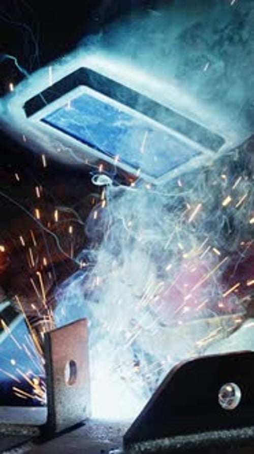 Las chispas de soldadura iluminan el taller durante una metalistería especializada