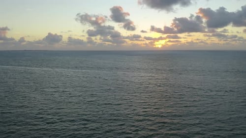 Superbe lever de soleil orange derrière des cumulus au-dessus de l'océan. Vue aérienne à vol d'oiseau. Océan vide, Horizo