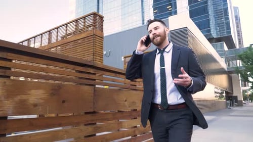 Businessman in Suit Walking and Talking on Smart Phone in City Adult