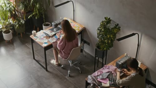 Top View of Two Seamstresses Working on Handmade Garments in Studio