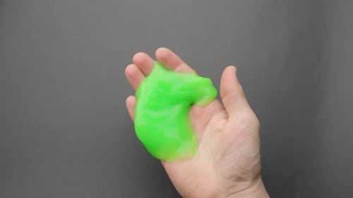 Green Sticky Slime Kneaded and Held in a Caucasian Hand Close-Up