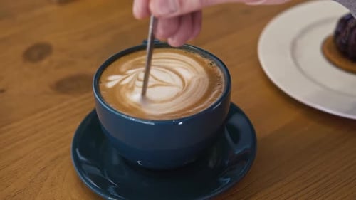 Stirring Latte with a Spoon in Blue Cup