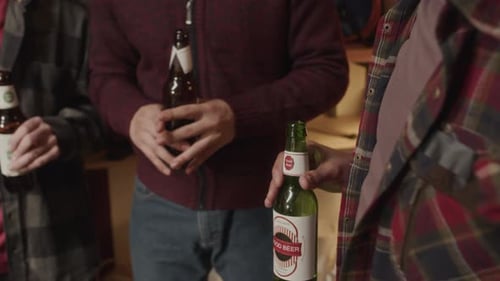 Men Holding Beer Bottles Socializing Indoors
