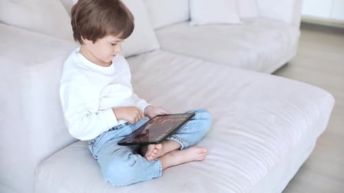 Young Boy Relaxing at Home with Tablet