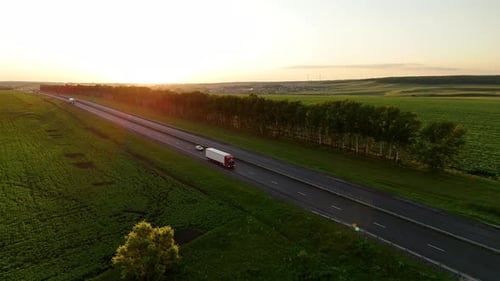 Heavy Truck Driving on an Asphalt Road Along Green Fields Aerial Shot
