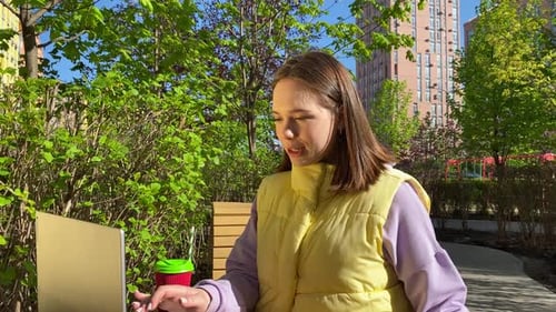 Charming Young Woman Call Her Small Dog While Working at City Park