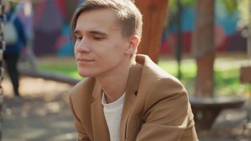 Young Man with Baby on Swing Set in Park