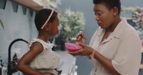 Child Eating Food from Bowl Held by Adult