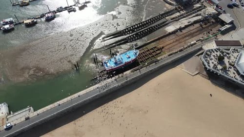 Aerial View of Boat on Beach and Coastal City