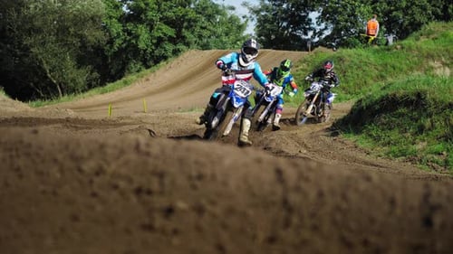 Dirt bike race. Motocross tournament. Riders coming in to a turn. Leaning on a turn. Motorcycle spor