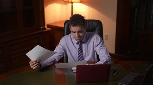 A Professional Man Reviewing Important Documents in a Corporate Office Environment
