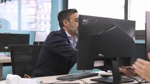 Mature Man Working at Computer in Modern Office