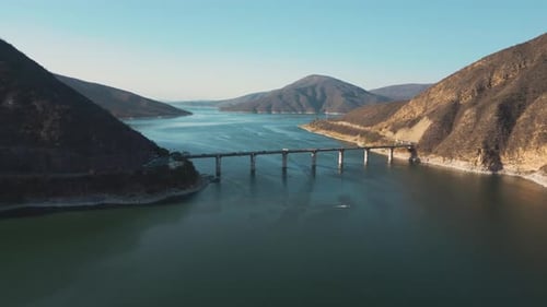 Aerial drone flying over a lake, water dam, with mountains at sunrise. Beautifull dreamy landscape v