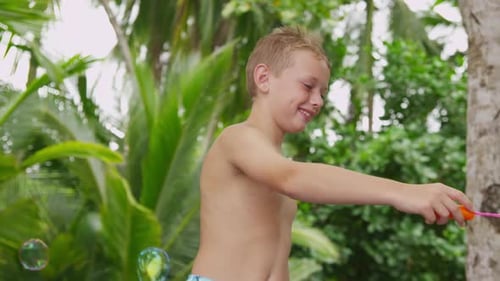 Garçon tropical faisant des bulles en vacances