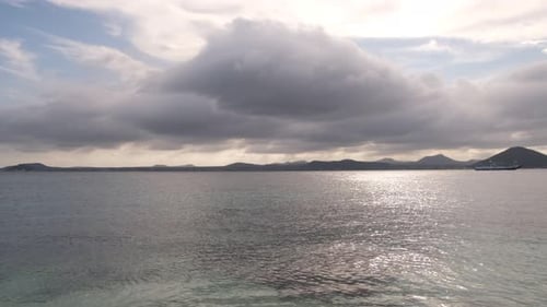 Wide angle shot of endless ocean water and mountains on horizon