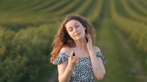 Woman Sprays Perfume in Rural Setting