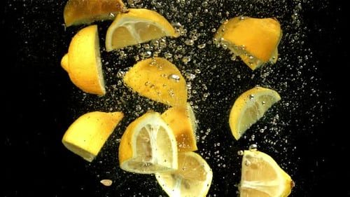 Lemon Slices Falling into Water with Bubbles