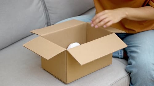 Woman unboxes new white wireless headphones at home
