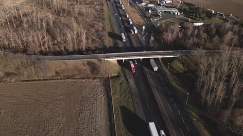 Drone footage of a highway overpass shows vehicles traveling on both the main road and the bridge ab