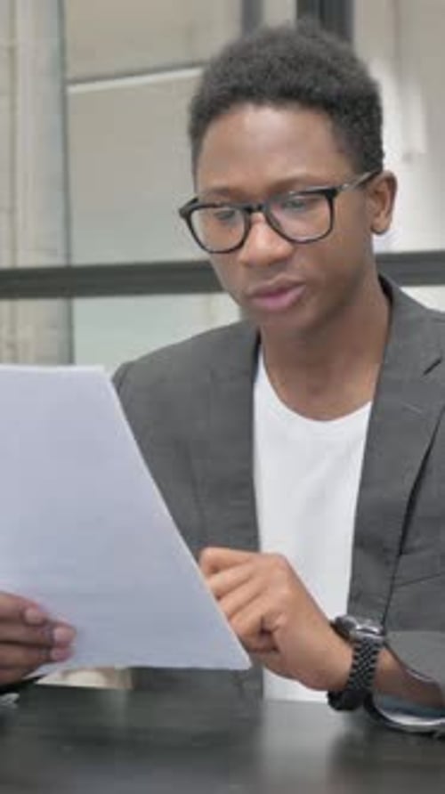 Young Man Reviews Documents in an Office Setting