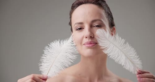 Woman with Feathers Posing in Studio